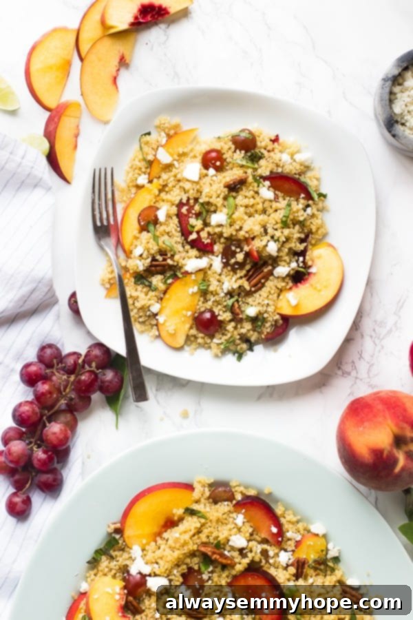 Top-down shot of quinoa stone fruit salad on a square plate with slices of peach on the side.