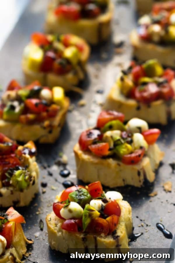 Blog Anniversary Special: 10 Minute Avocado Caprese Bruschetta 2 Two rows of avocado caprese bruschetta topped with a balsamic reduction on a grey slate.