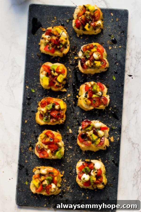 Blog Anniversary Special: 10 Minute Avocado Caprese Bruschetta 4 Top down shot of avocado caprese bruschetta on a grey slate.
