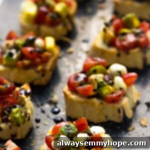 Side view of freshly prepared avocado caprese bruschetta on a grey slate, highlighting its vibrant layers.