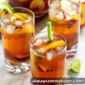 3 glasses of peach sangria set in front of pitcher