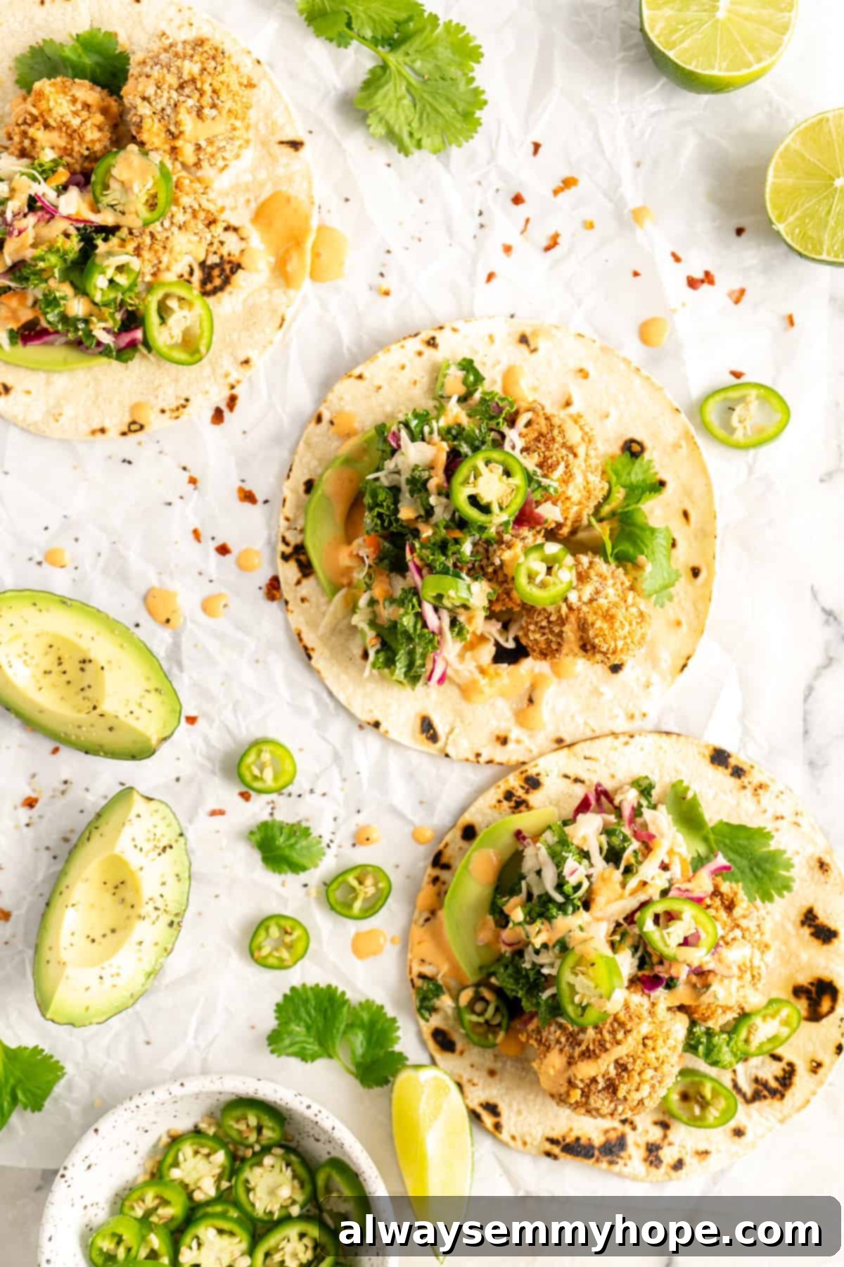 Crunchy Cauliflower Tacos with Smoky Chipotle Crema 4 Overhead shot of beautifully assembled Crispy Cauliflower Tacos with garnishes like lime, cilantro, and jalapeños