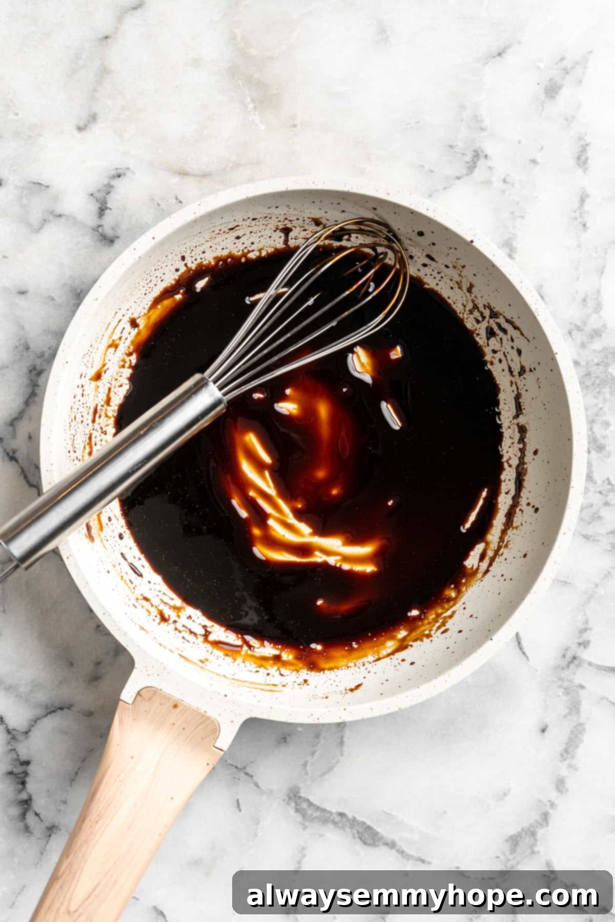 Overhead view of balsamic reduction in saucepan with whisk