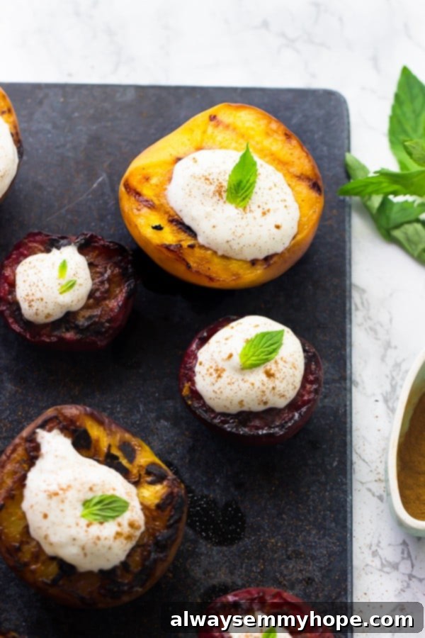 Flame-Kissed Fruit with Coconut Dream 2 Top-down shot of beautifully grilled stone fruit halves, showcasing caramelized edges, served on a rustic grey slate, hinting at the deliciousness within this easy summer dessert.