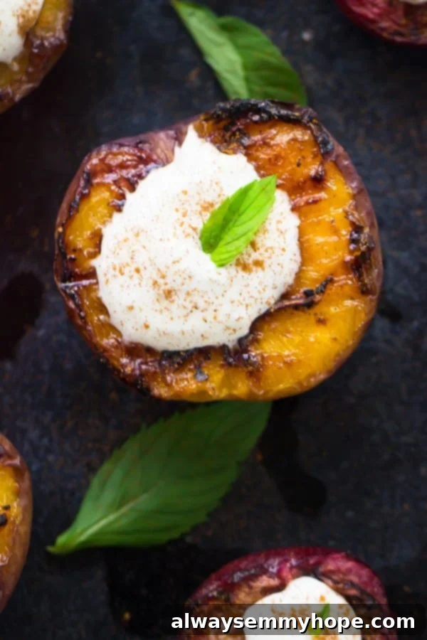 Flame-Kissed Fruit with Coconut Dream 4 Close-up detailed shot of a perfectly grilled peach half, adorned with a generous swirl of homemade coconut cream and a sprinkle of cinnamon, showcasing the rich textures of this simple grilled stone fruit dessert.
