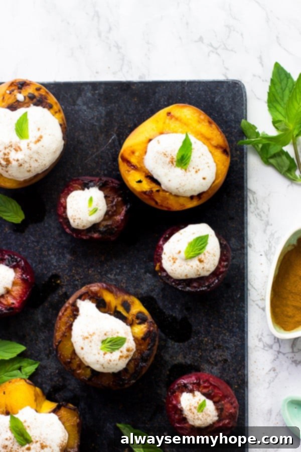 Flame-Kissed Fruit with Coconut Dream 5 An overhead shot of vibrant grilled fruit, lavishly topped with fluffy coconut cream and a dusting of cinnamon, artfully arranged on a dark grey slate, ready to be enjoyed as a refreshing summer dessert.