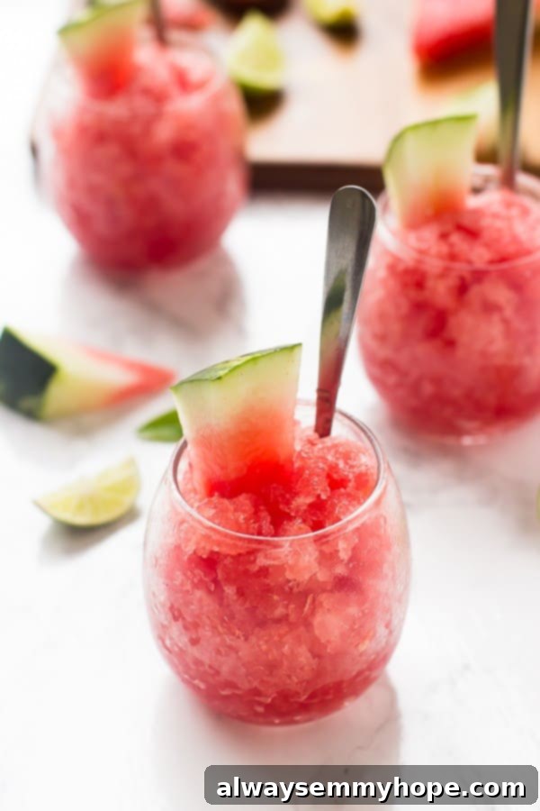 Watermelon granita in glasses with a silver spoon in them.
