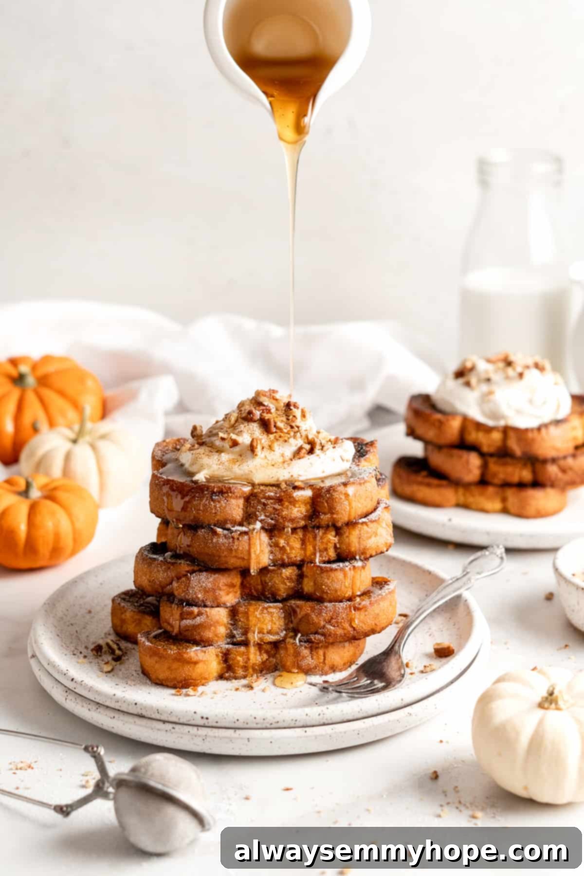 Pouring syrup over stack of pumpkin French toast topped with coconut cream and nuts