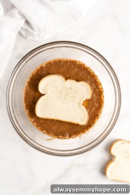 Bread being dipped into French toast batter