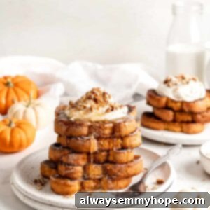 Two plates with stacks of pumpkin French toast garnished with whipped cream and nuts