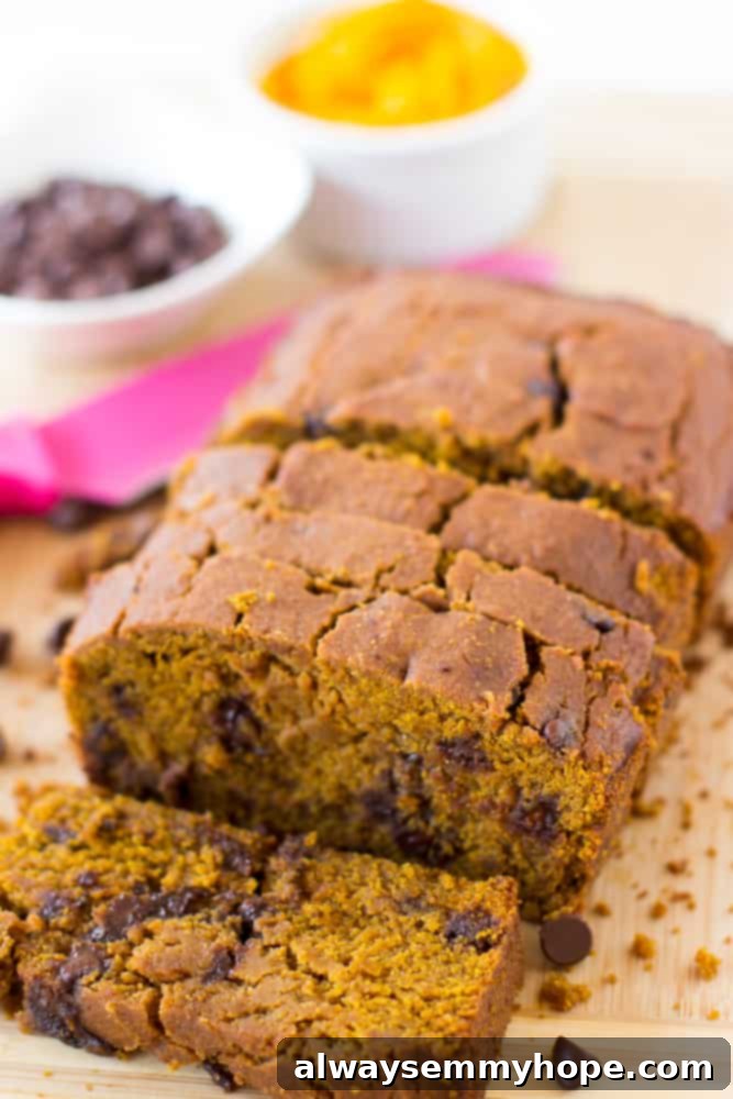 Sliced vegan pumpkin chocolate chip bread on a wooden board.