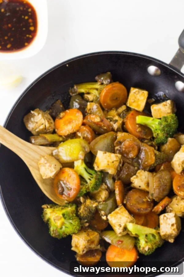Top down shot of asian tofu stir fry in a black skillet.