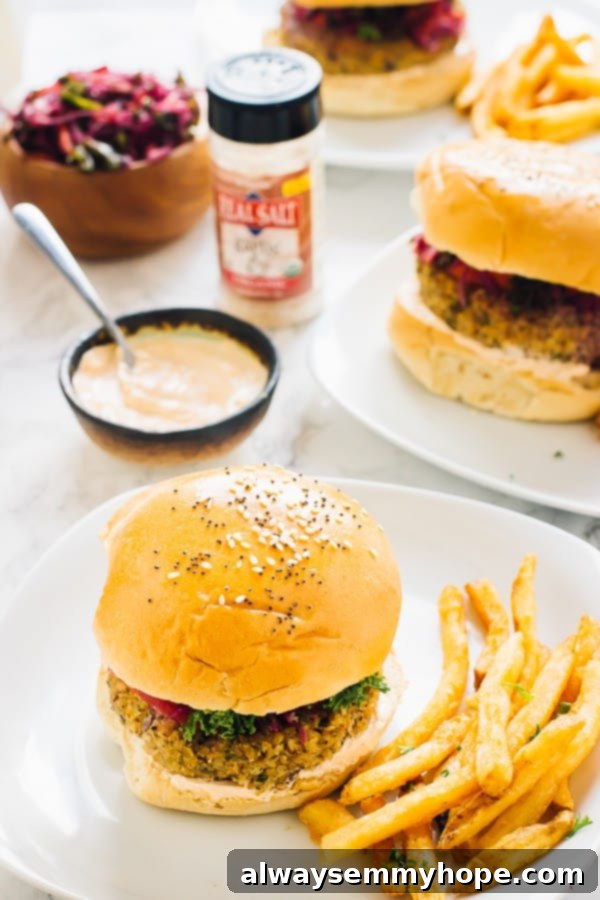 Two vegan quinoa cauliflower burgers on a white plates with fries on the side. 