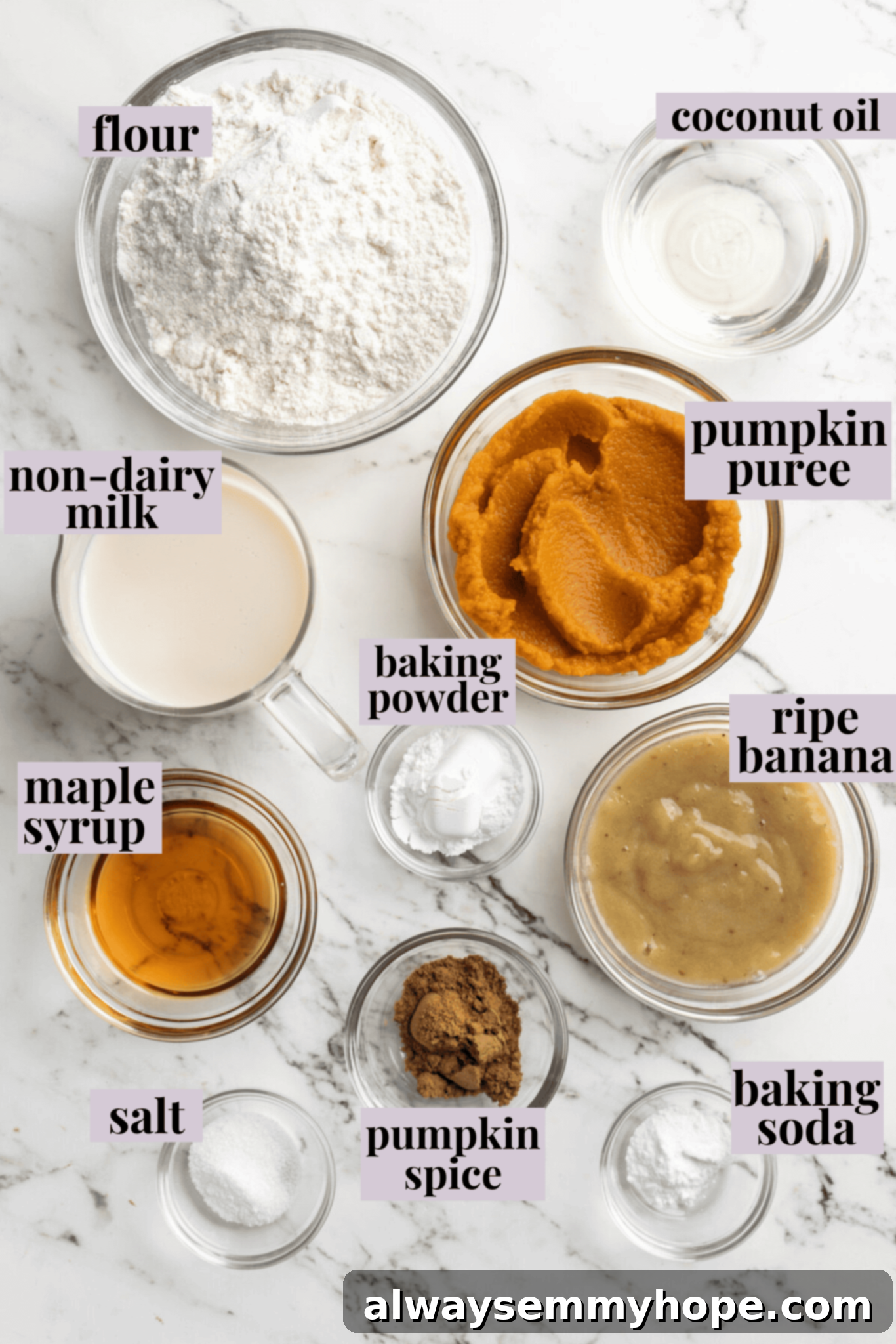 These easy vegan pumpkin waffles are light, fluffy, and crispy, with your favorite fall flavors, and can easily be made gluten-free. Overhead view of the ingredients needed for pumpkin waffles: a bowl of flour, a bowl of pumpkin puree, a pyrex of non-dairy milk, a glass of agave, a bowl of mashed banana, a glass of coconut oil, a bowl of pumpkin spice, a bowl of salt, a bowl of baking powder, and a bowl of baking soda