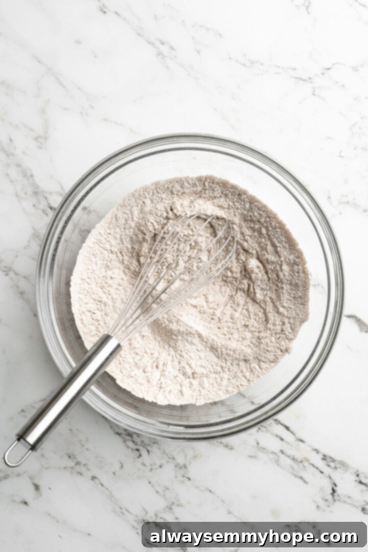 These easy vegan pumpkin waffles are light, fluffy, and crispy, with your favorite fall flavors, and can easily be made gluten-free. A mixing bowl with flour and other dry ingredients and a whisk