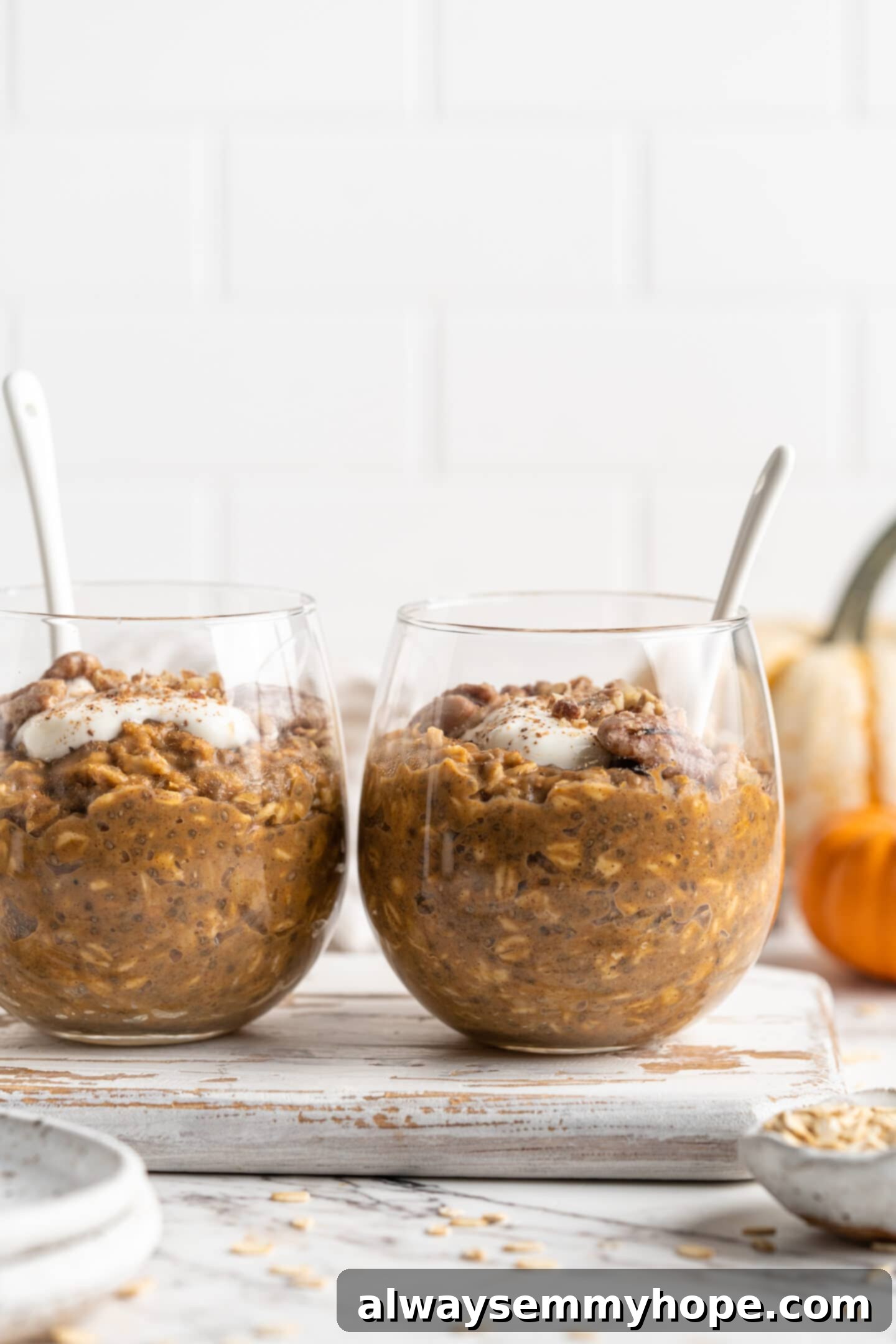 two jars of pumpkin pie overnight oats with spoons inside head on shot, perfect for meal prepping a healthy breakfast