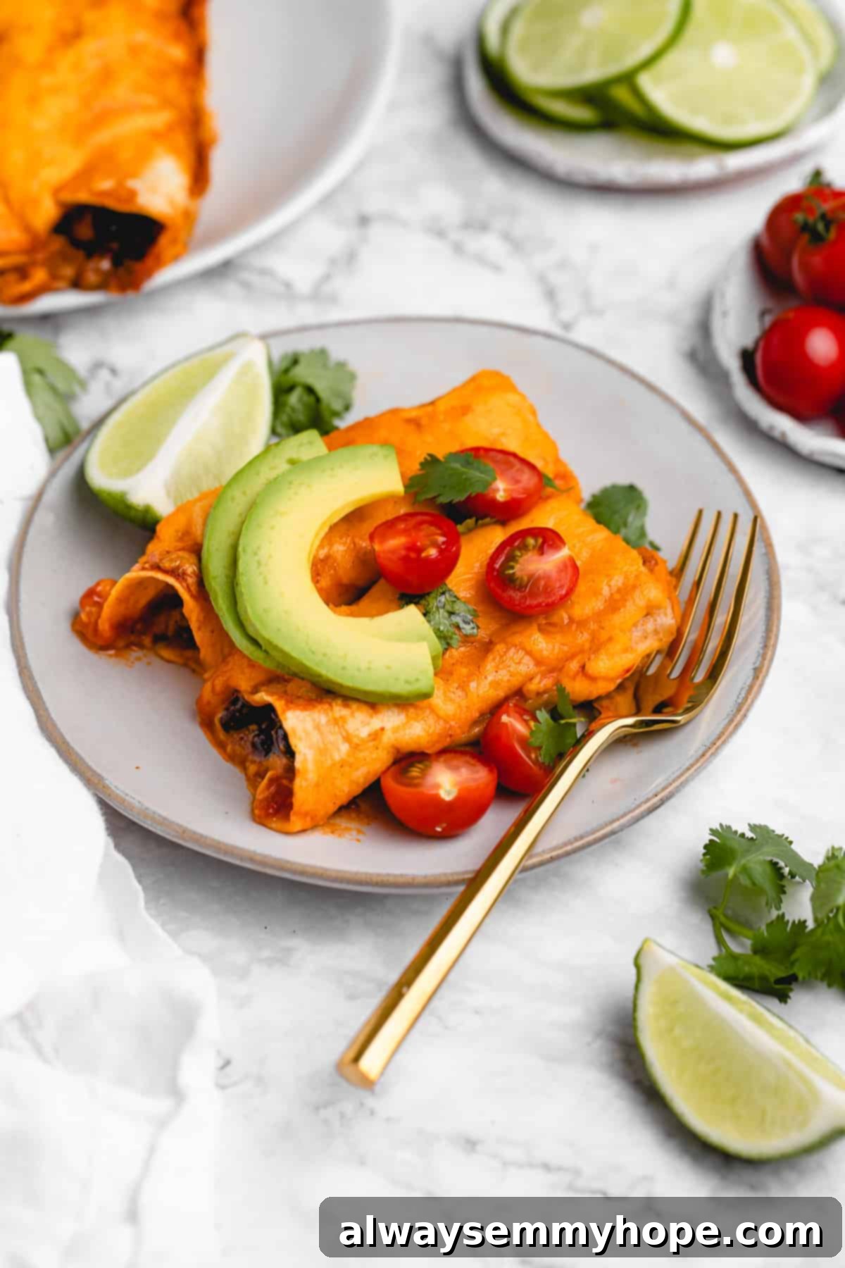 Plate of cheesy enchiladas with a wedge of lime.