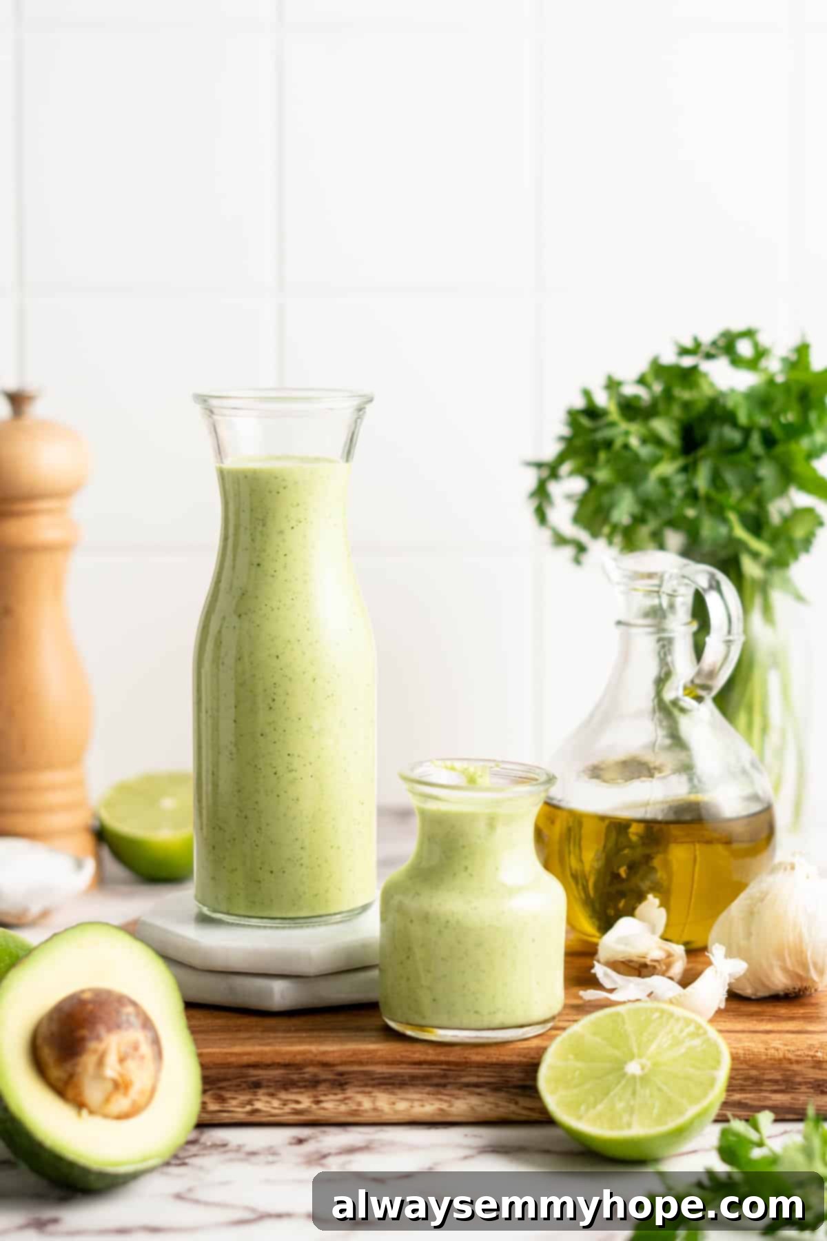 Naturally Creamy Vegan Avocado Dressing 7 Two different sizes of clear glass jars filled with vibrant green creamy vegan avocado dressing, ready for storage.