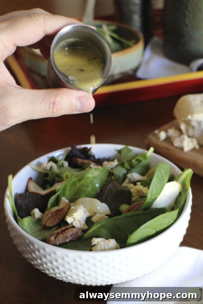 Quick Fall Vegan Dinners: 25 Recipes Ready in 15 Minutes 12 Hand pouring dressing over a fresh pecan apple salad in a white bowl.