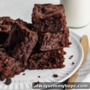 Chewy and Fudgy Vegan Brownies 12 Brownies stacked on a plate with knife beside it.