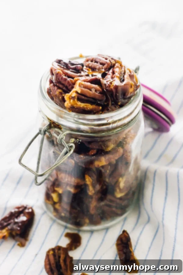 Jar of homemade candied pecans, showcasing their golden hue and inviting texture, ready for snacking or topping.