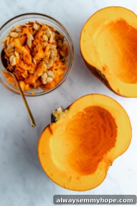 One half of a pumpkin with seeds and stringy fibers removed, ready for further preparation. Next to it, a small jar filled with the removed seeds.