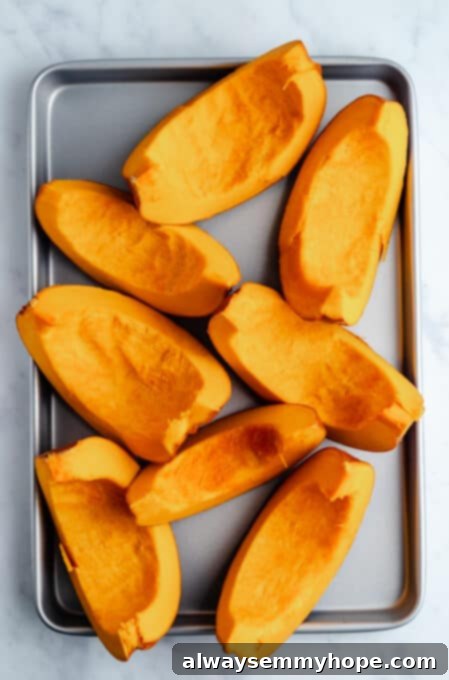 Sliced pumpkin wedges laid out neatly on a baking sheet, prepared for roasting in the oven.