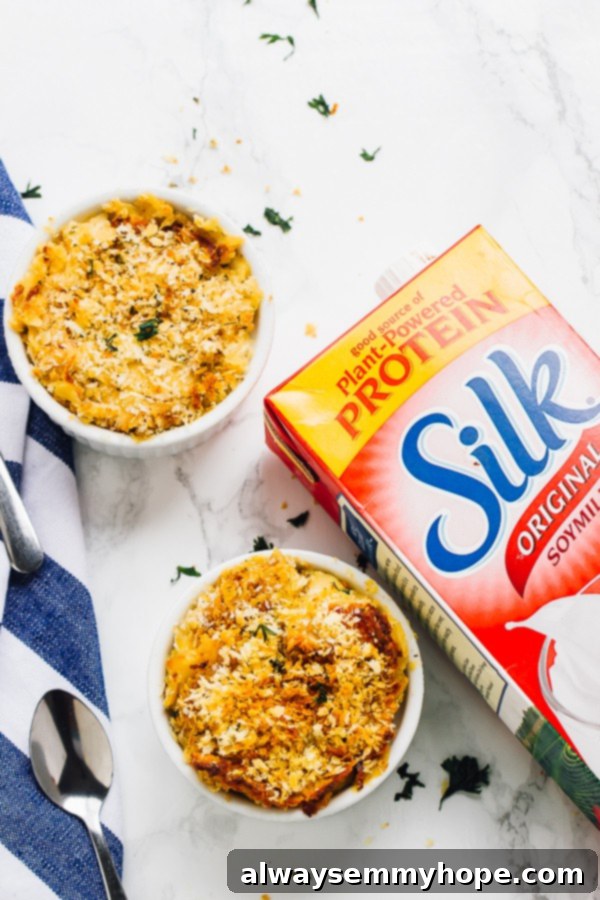 Loaded with fall flavour and a creamy, decadent texture, this Vegan Pumpkin Mac and Cheese is the perfect fall side dish. An overhead shot showcasing two bowls of beautifully baked vegan pumpkin mac and cheese, garnished with fresh herbs.