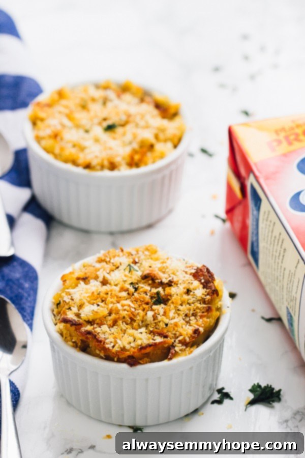 Loaded with fall flavour and a creamy, decadent texture, this Vegan Pumpkin Mac and Cheese is the perfect fall side dish. Two white ramekins showcasing baked vegan pumpkin mac and cheese, golden and bubbling.