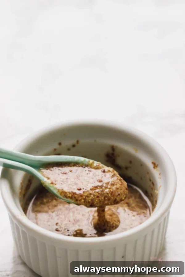 A blue spoon lifting some flax seed mix from a ramekin. 