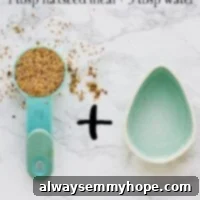 Overhead shot of flax seeds in a blue measuring spoon next to an egg shaped bowl.