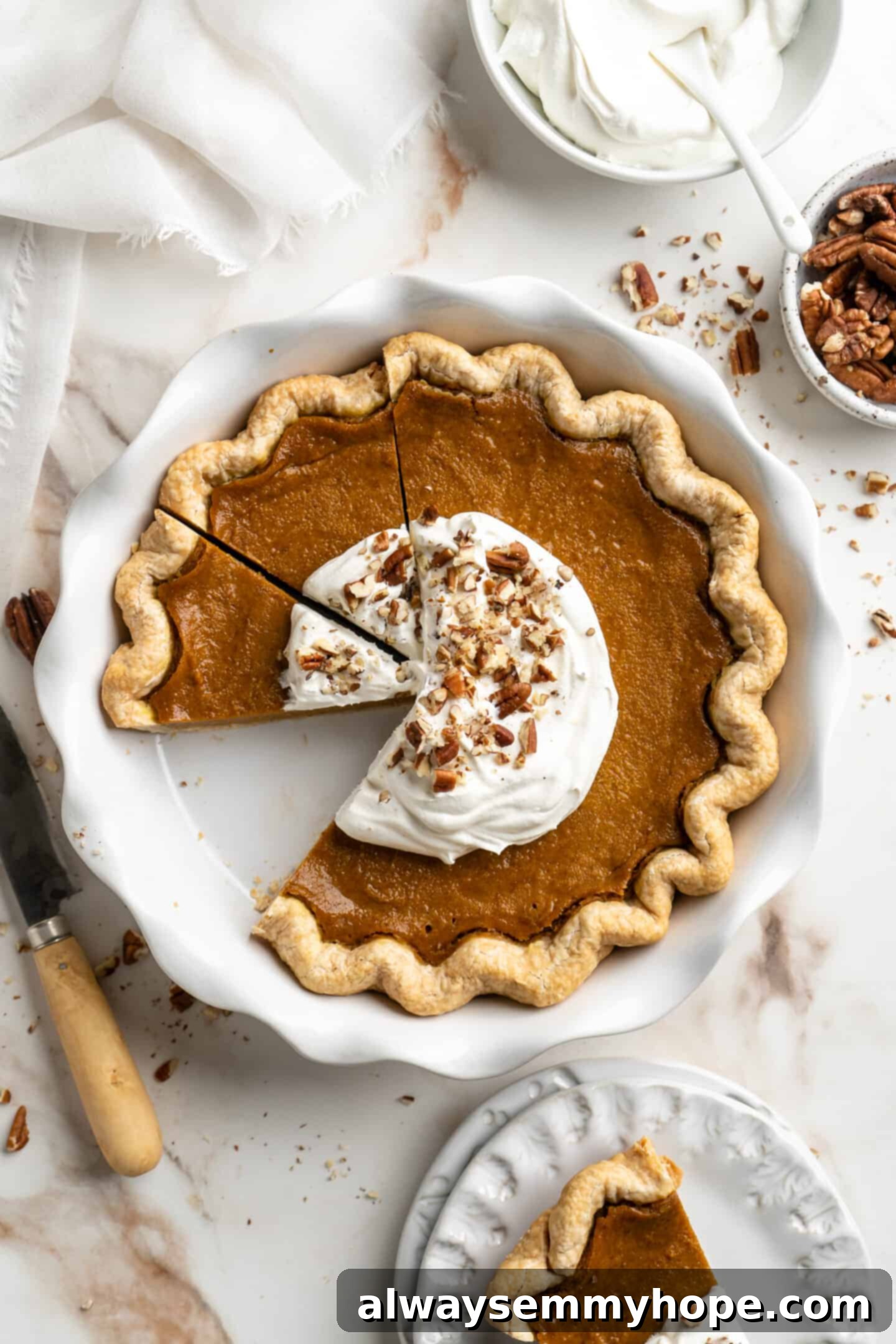 This homemade vegan pumpkin pie is perfectly silky, and tastes just like the traditional version! It's the best Thanksgiving dessert! Top down shot of sliced pumpkin pie in a pie dish.