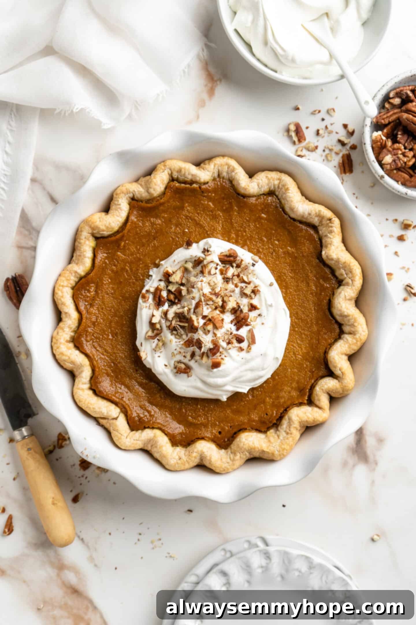 Easy 9-Ingredient Vegan Pumpkin Pie 12 fully baked pie crust with whipped coconut cream on top.
