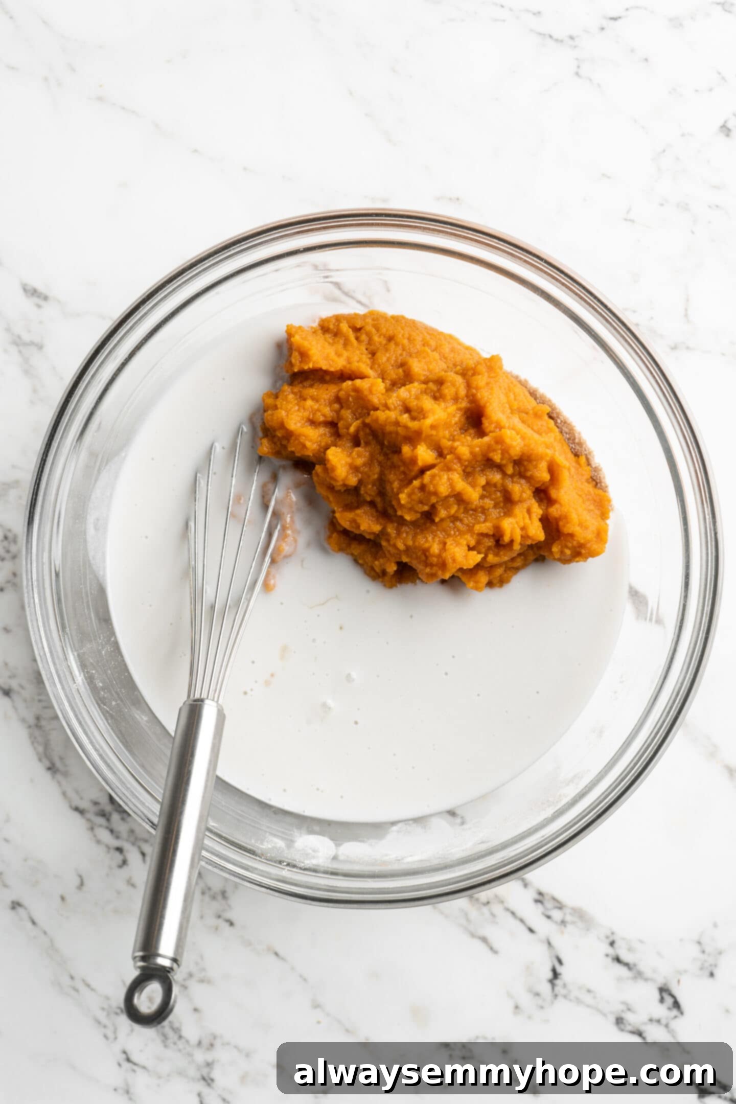 Easy 9-Ingredient Vegan Pumpkin Pie 7 pumpkin puree and coconut milk in a glass bowl added to the pie base with a whisk.
