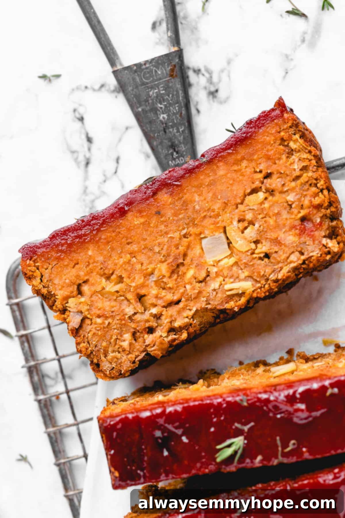 This vegan meatloaf makes a perfect Thanksgiving main dish or entree! It's moist and full of flavor, with just 15 minutes of prep. Dig in! Close up overhead view of vegan meatloaf cut into slices on a parchment-lined wire rack.