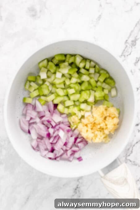 This vegan meatloaf makes a perfect Thanksgiving main dish or entree! It's moist and full of flavor, with just 15 minutes of prep. Dig in! Diced red onion, garlic, and celery added to a pan.