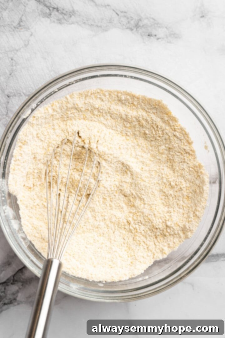 These moist vegan jalapeño cornbread muffins are easy to make and have a gluten-free option, which means everyone can enjoy them! Whisking dry ingredients in glass mixing bowl.