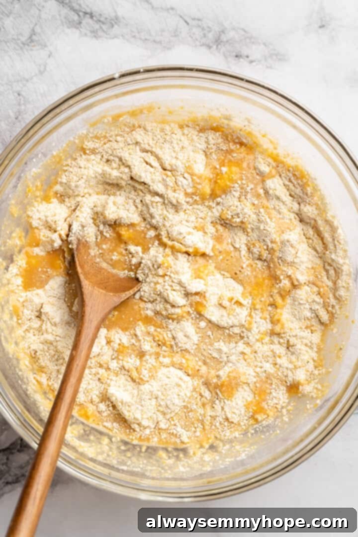 These moist vegan jalapeño cornbread muffins are easy to make and have a gluten-free option, which means everyone can enjoy them! Mixing dry and wet ingredients for cornbread in mixing bowl.