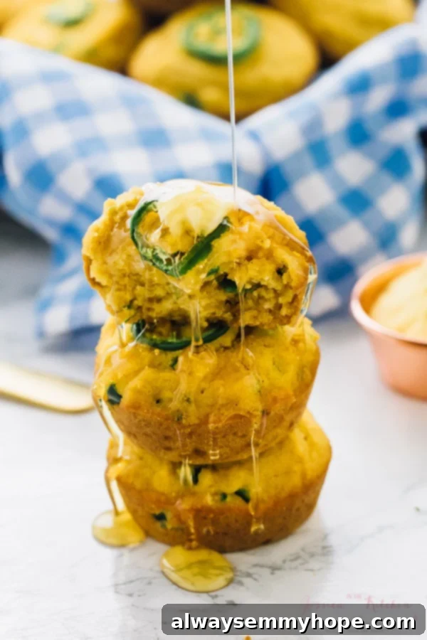 A stack of three gluten free cornbread muffins being drizzled with honey.