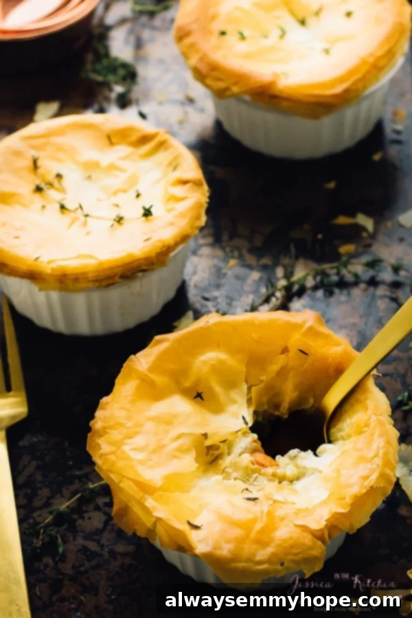 Three vegan pot pies in white ramekins with a golden fork on the side. 
