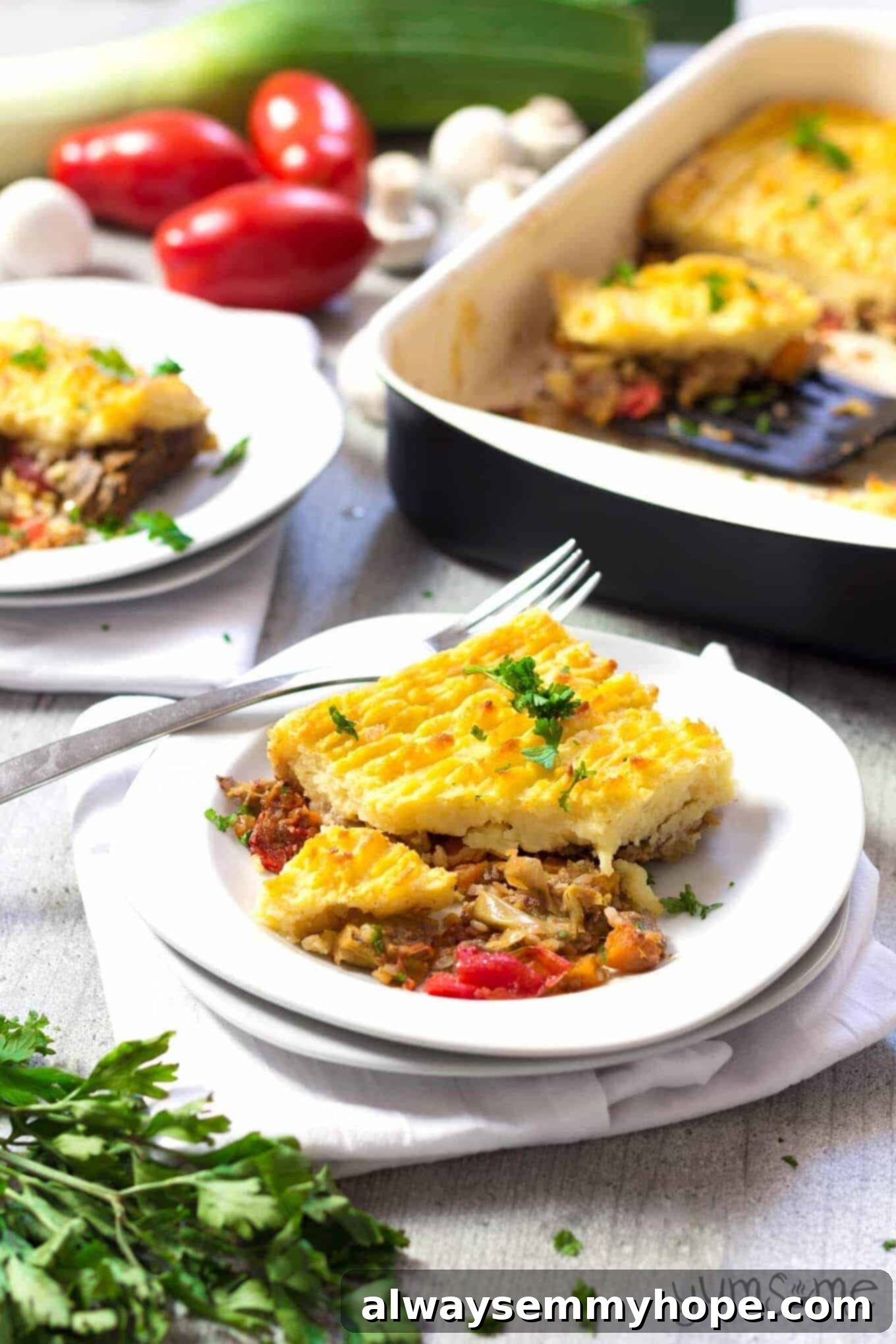 A portion of vegan mushroom buckwheat shepherds pie on a white plate with pie in the background. 
