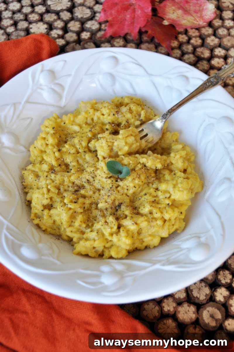 Risotto with vegan pumpkin sage cream sauce in a white bowl with a fork.