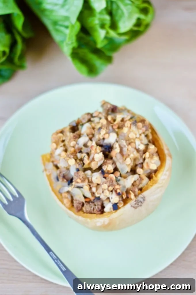 Mushroom and lentil stuffed butternut squash on a blue plate with a fork on the side. 
