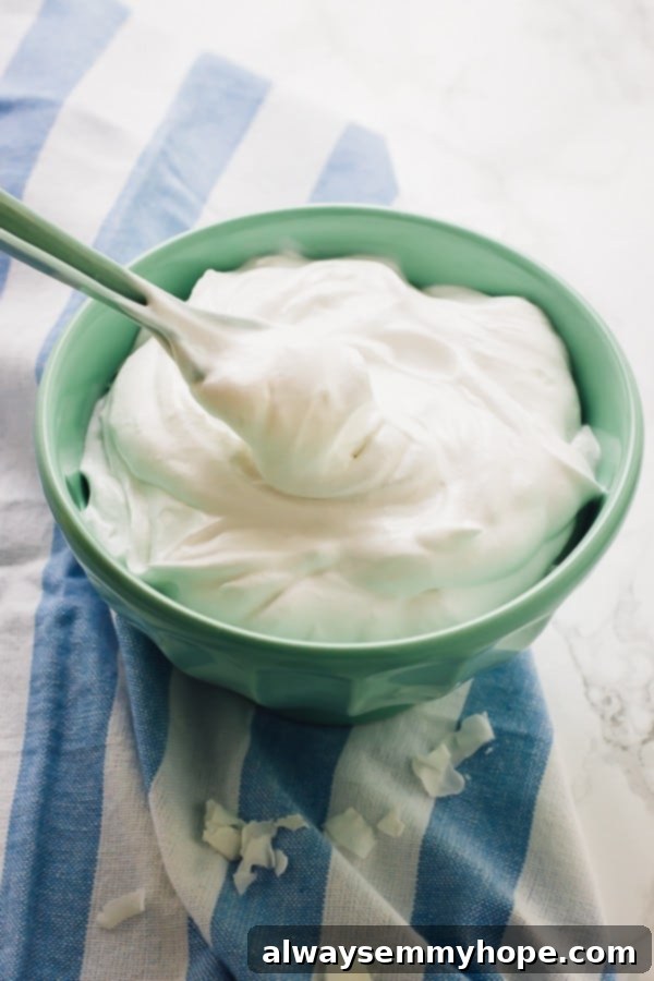 Coconut whipped cream in a blue bowl with a spoon. 