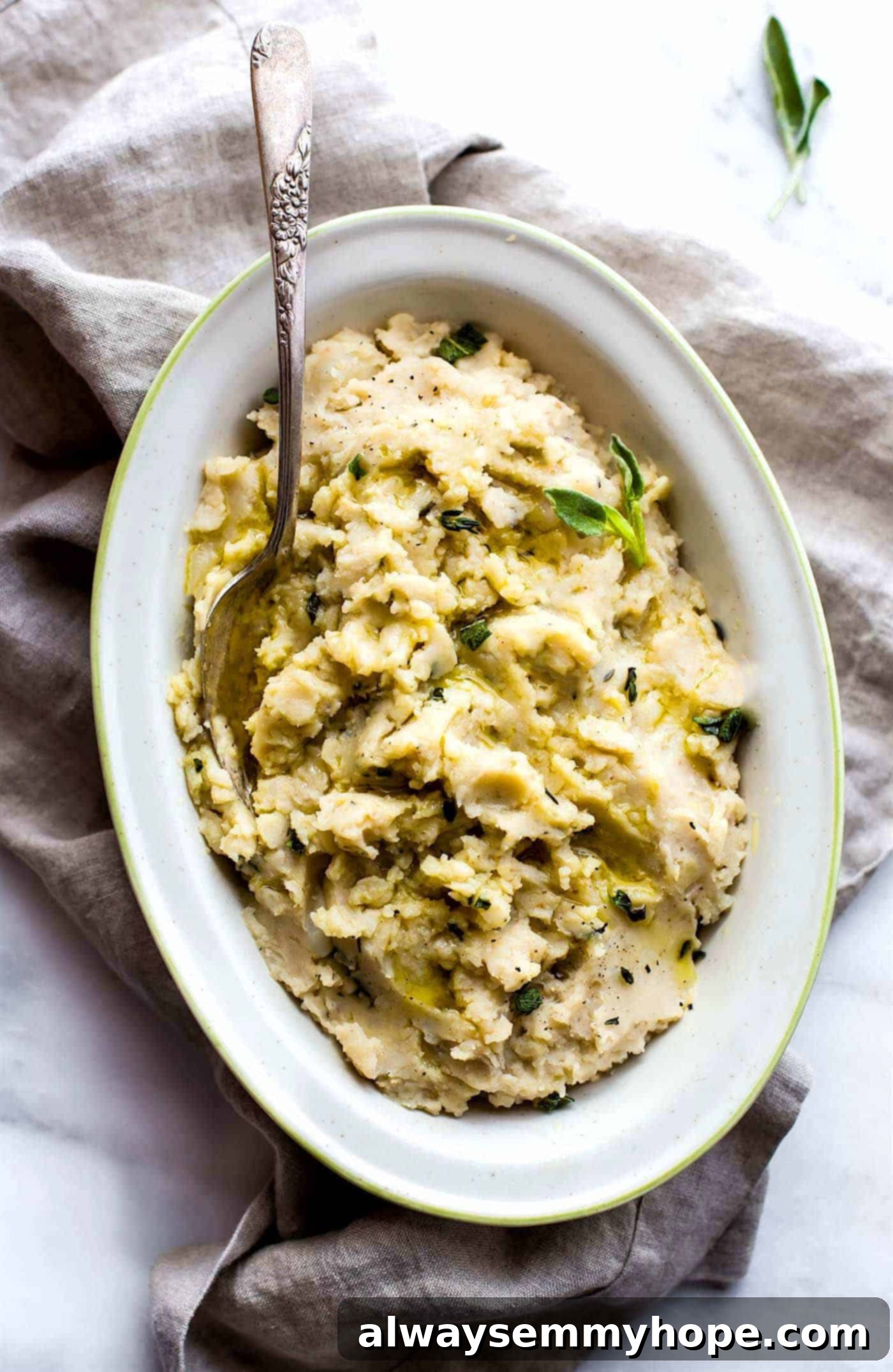 Top down shot of vegan white bean mashed-potatoes on a long white plate.