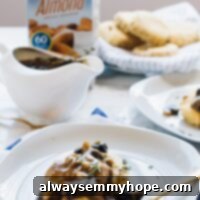 Vegan mushroom gravy on top of biscuits with a carton of almond milk in the background.