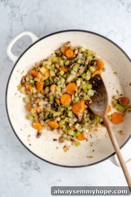 Hearty Vegan Shepherd's Pie 5 Overhead shot of vegetables simmering and softening in a Dutch oven with vegan butter for the Shepherd's Pie filling