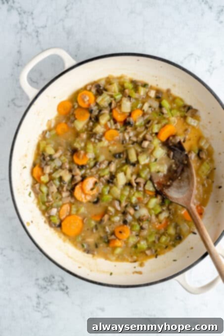Hearty Vegan Shepherd's Pie 8 Overhead shot of Shepherd's Pie filling simmering and thickening in a large Dutch oven with a wooden spoon