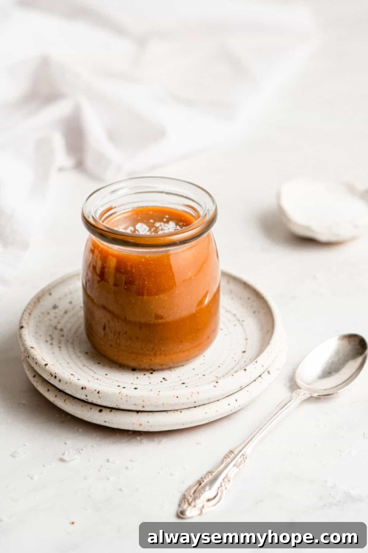 Simple Plant-Based Caramel 2 Rich vegan caramel sauce with a sprinkle of sea salt on top, served in a small bowl.
