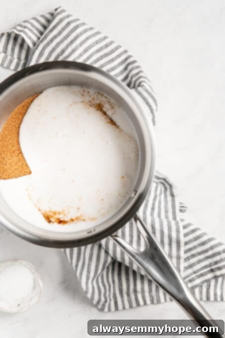 Simple Plant-Based Caramel 5 Brown sugar being mixed with full-fat coconut milk in a saucepan, forming a liquid mixture.